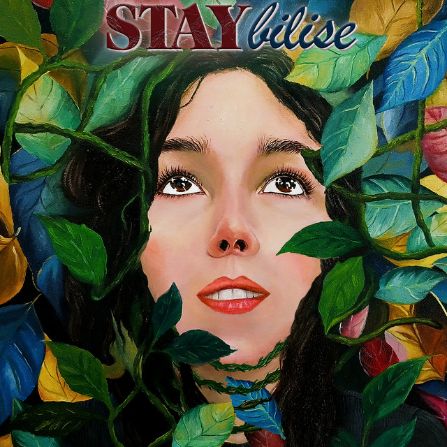 STAYbilise cover art: a painted portrait of Emily looking up, surrounded by lush multicoloured leaves